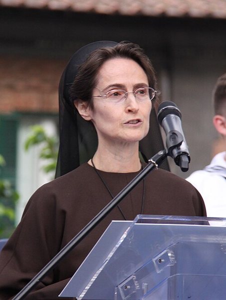 Sister Raffaella Petrini in Franciscan habit speaking at a lectern